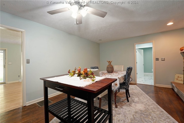 dining area with ceiling fan, a textured ceiling, and dark wood-type flooring