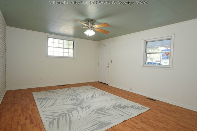 spare room featuring ornamental molding, ceiling fan, plenty of natural light, and hardwood / wood-style floors