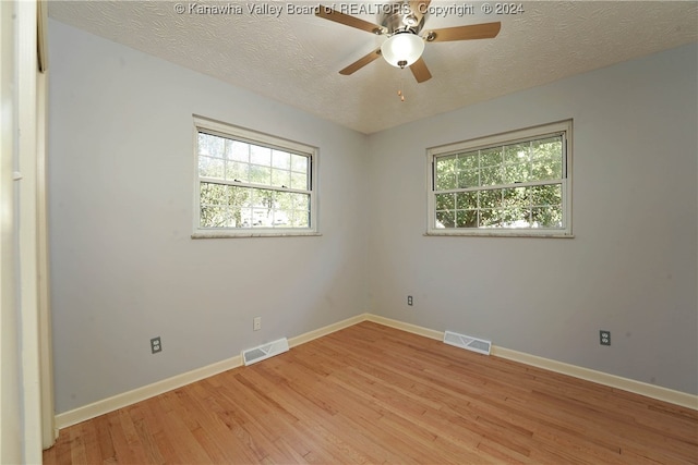 spare room featuring ceiling fan, a textured ceiling, and light wood-type flooring