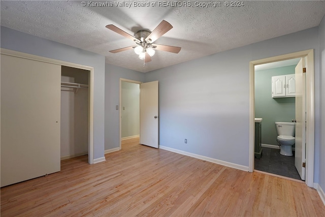 unfurnished bedroom featuring connected bathroom, light hardwood / wood-style floors, ceiling fan, and a textured ceiling