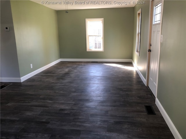 unfurnished room with dark hardwood / wood-style floors and a healthy amount of sunlight