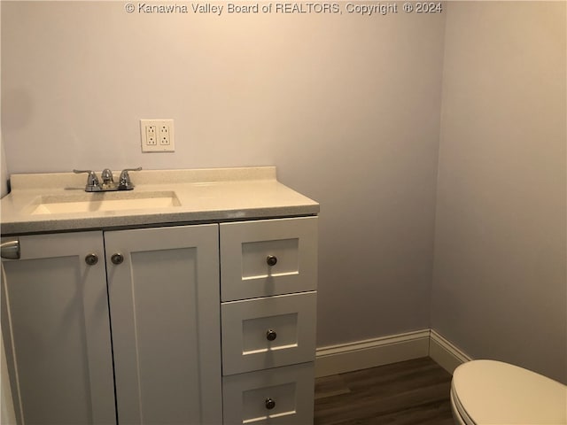 bathroom featuring hardwood / wood-style flooring, vanity, and toilet