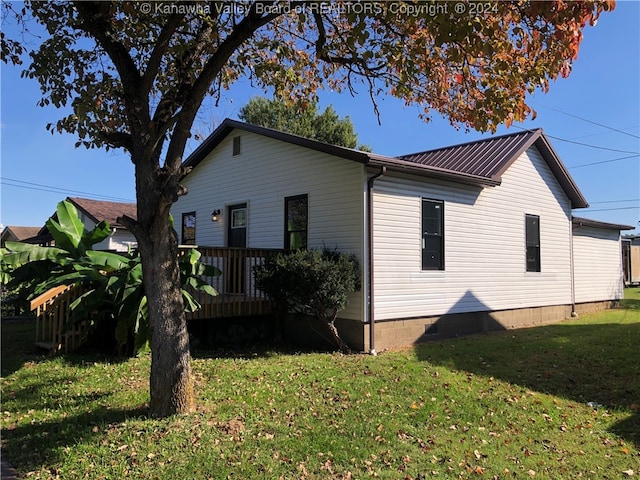 view of property exterior featuring a wooden deck and a yard