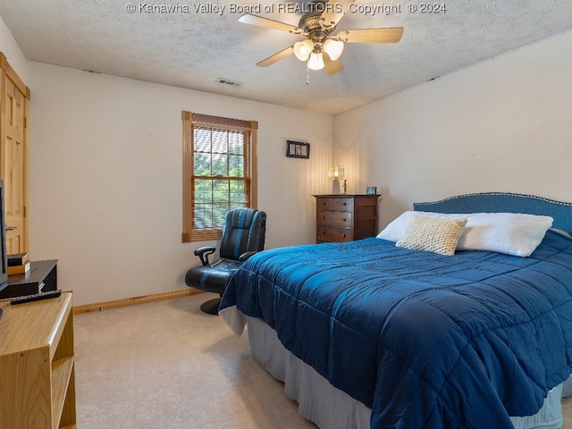 carpeted bedroom featuring a textured ceiling and ceiling fan