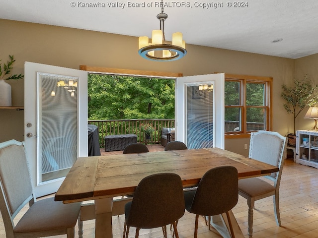 dining room featuring light wood-type flooring and a notable chandelier