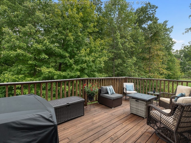 wooden terrace featuring area for grilling and an outdoor hangout area