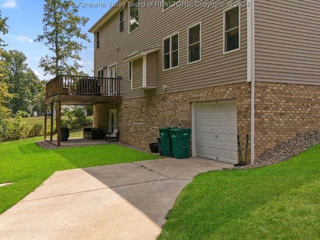 back of house with a garage, a lawn, and a deck