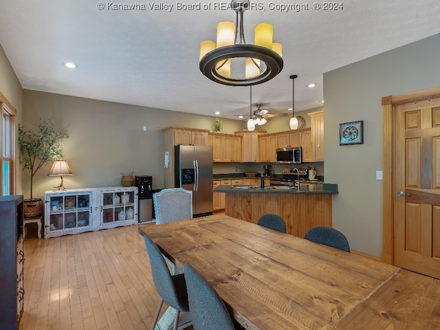 dining area with light wood-type flooring and ceiling fan