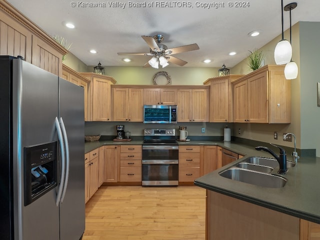 kitchen with light hardwood / wood-style floors, hanging light fixtures, a textured ceiling, sink, and appliances with stainless steel finishes