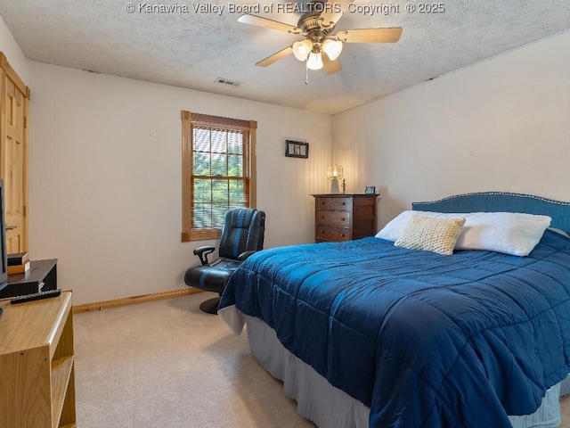 carpeted bedroom with ceiling fan and a textured ceiling