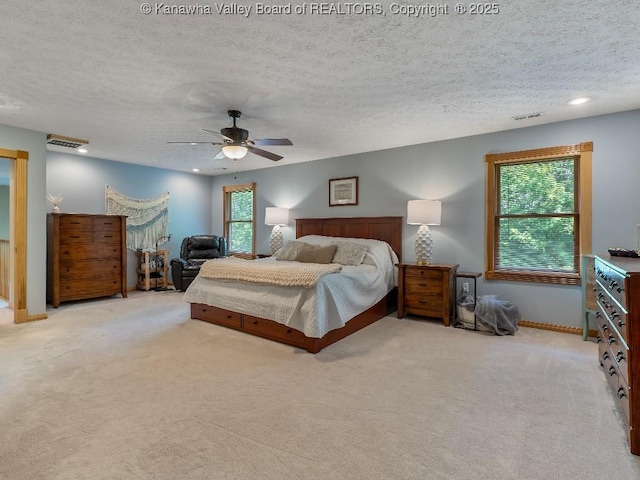 carpeted bedroom featuring a textured ceiling and ceiling fan