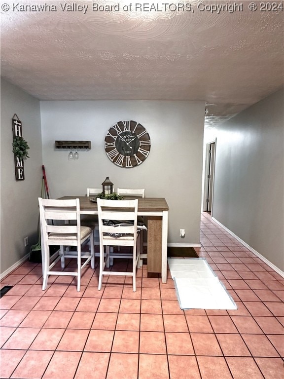 unfurnished dining area featuring a textured ceiling and light tile patterned floors