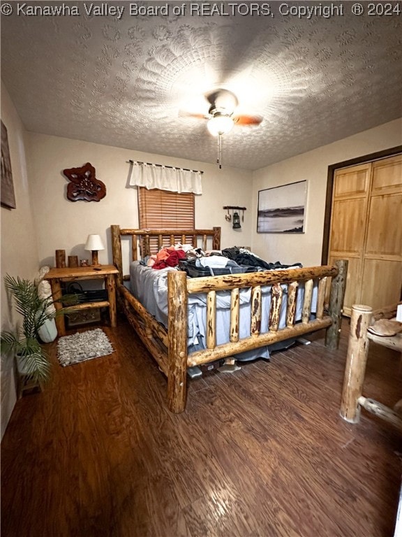 bedroom with ceiling fan, dark hardwood / wood-style floors, and a textured ceiling