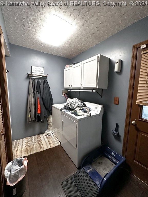 washroom with dark wood-type flooring, washer and dryer, cabinets, and a textured ceiling