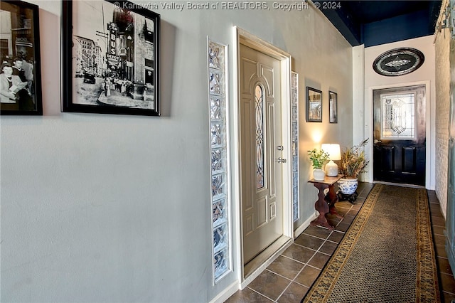 foyer entrance with dark tile patterned flooring