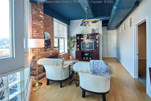 living room with brick wall and light hardwood / wood-style floors