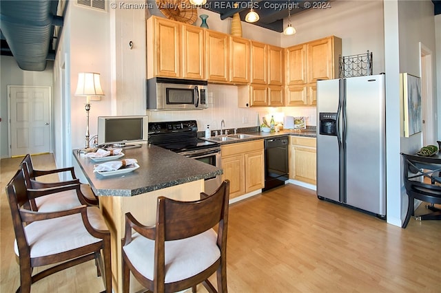 kitchen with light brown cabinets, sink, light hardwood / wood-style flooring, black appliances, and decorative backsplash