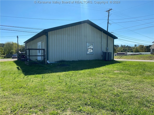 view of outdoor structure with central AC and a yard