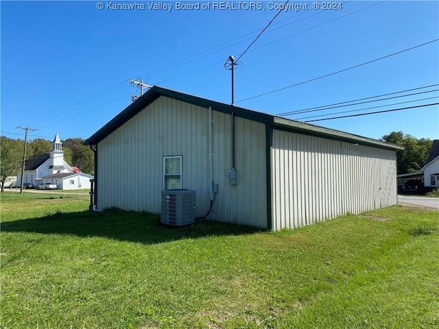 view of outdoor structure featuring central AC and a lawn