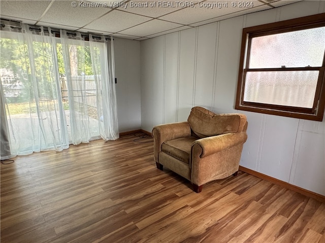 sitting room featuring a drop ceiling and hardwood / wood-style floors