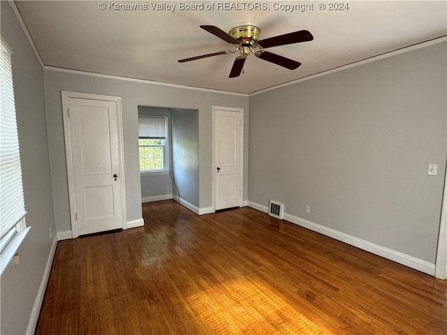 unfurnished bedroom with ornamental molding, dark hardwood / wood-style floors, and ceiling fan