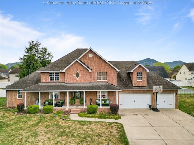 view of front of house with a mountain view, a garage, a front lawn, and covered porch