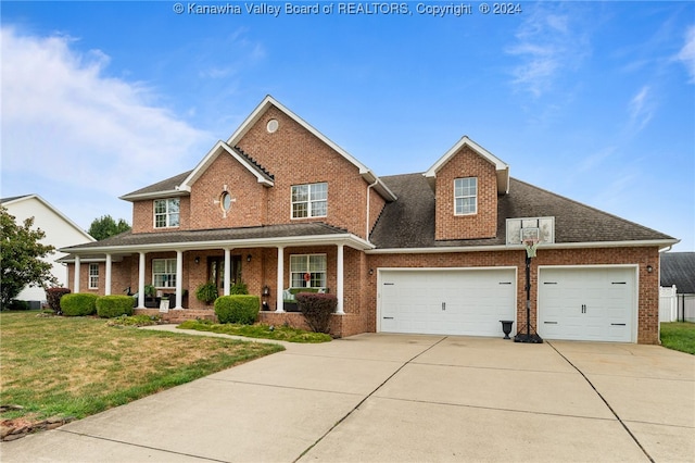 view of front facade with a front lawn, covered porch, and a garage