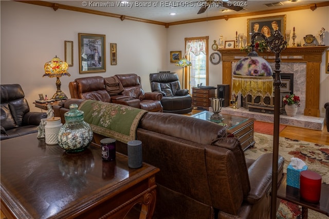 living room with crown molding, hardwood / wood-style floors, a premium fireplace, and ceiling fan