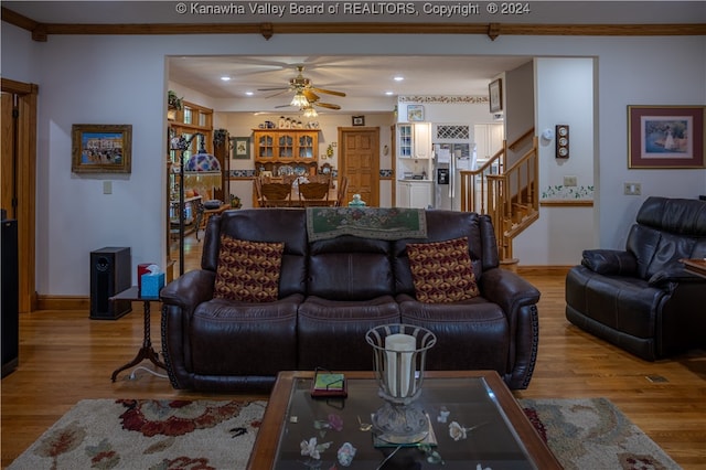 living room with crown molding, ceiling fan, and light hardwood / wood-style flooring