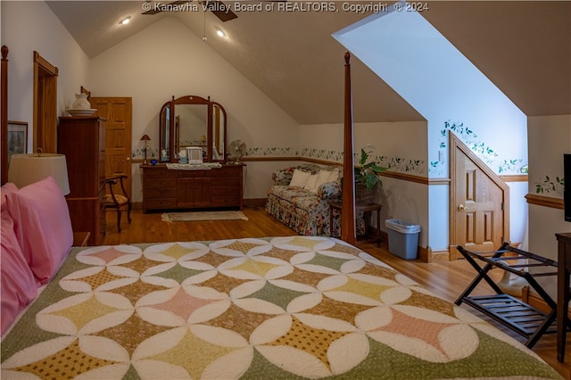 bedroom with vaulted ceiling with skylight and light hardwood / wood-style flooring