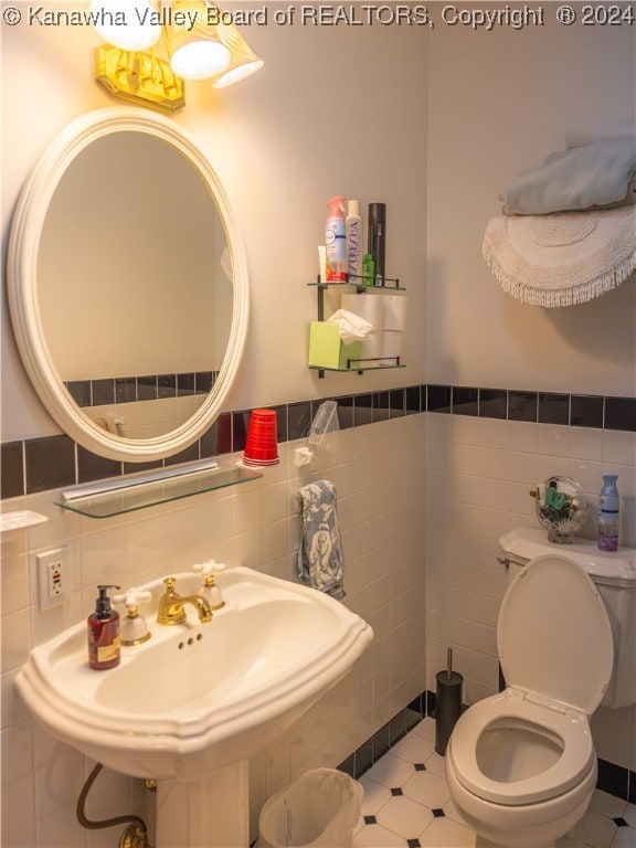 bathroom featuring tile walls, sink, and toilet