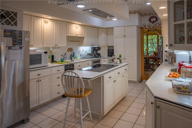 kitchen with white cabinets, stainless steel fridge, and a center island