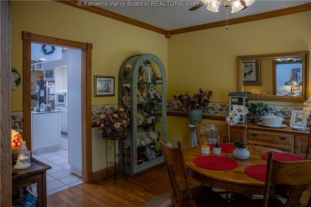 dining space with ornamental molding, light wood-type flooring, and ceiling fan