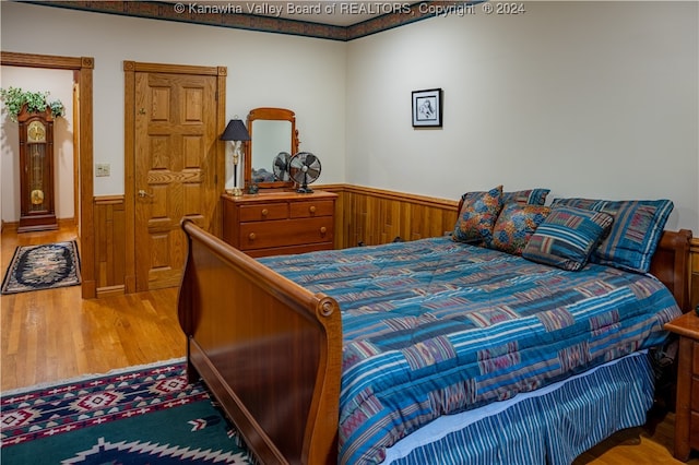 bedroom featuring hardwood / wood-style flooring and wood walls