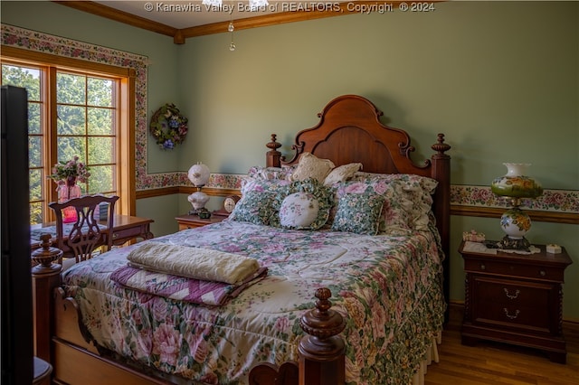 bedroom featuring wood-type flooring and crown molding