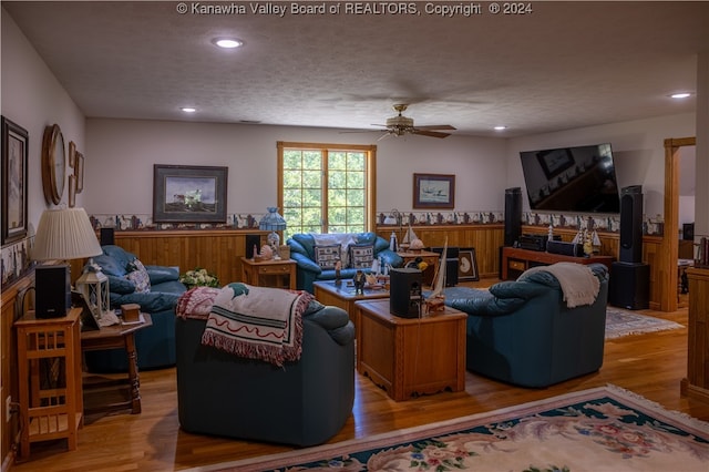 living room featuring hardwood / wood-style flooring, a textured ceiling, and ceiling fan