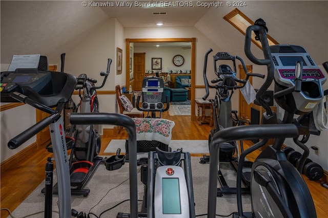 workout area with wood-type flooring and vaulted ceiling