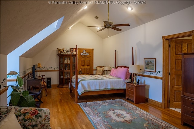 bedroom featuring light wood-type flooring, ceiling fan, and lofted ceiling