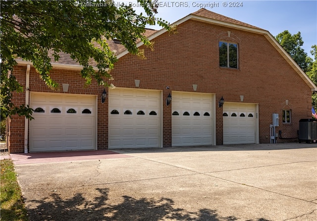 view of home's exterior with cooling unit and a garage