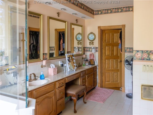 bathroom featuring vanity and tile walls