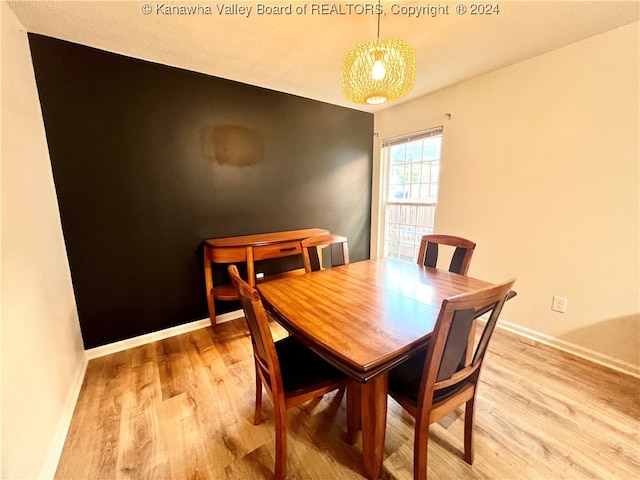 dining area featuring an inviting chandelier and light hardwood / wood-style floors