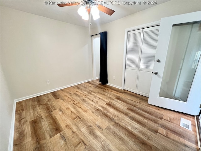 unfurnished bedroom with ceiling fan and light wood-type flooring