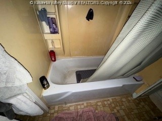 bathroom with shower / tub combo with curtain