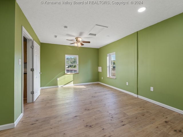 spare room featuring a textured ceiling, light hardwood / wood-style floors, and ceiling fan