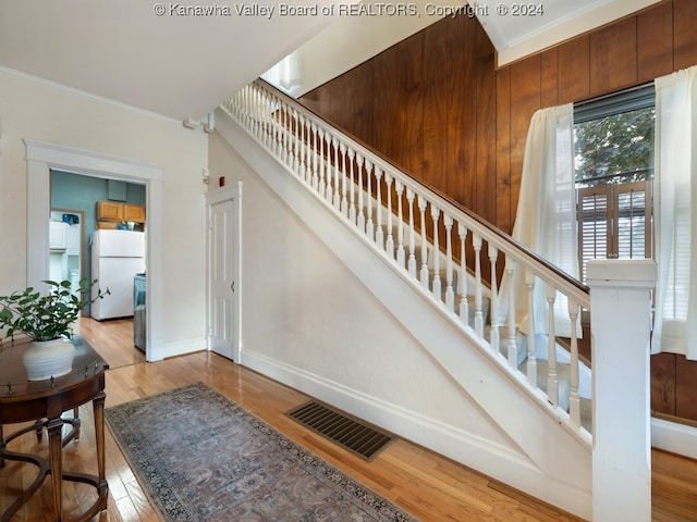 stairway featuring ornamental molding and wood-type flooring