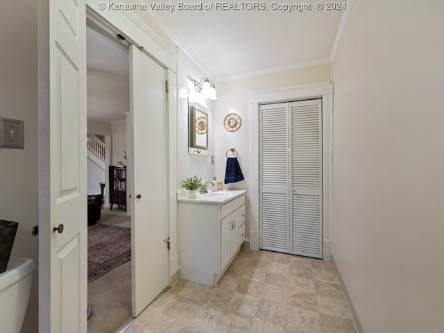 bathroom featuring vanity, ornamental molding, and toilet