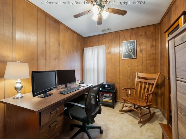 office space with ceiling fan, wood walls, and light colored carpet