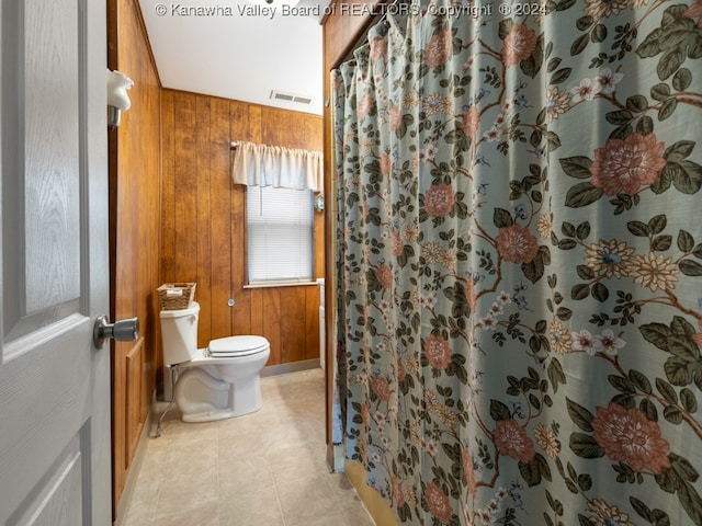 bathroom featuring tile patterned floors, a shower with curtain, toilet, and wood walls