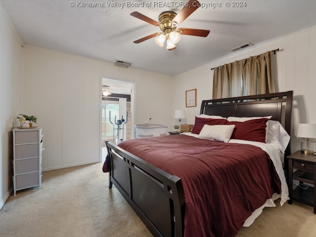 carpeted bedroom with ceiling fan, a textured ceiling, and ornamental molding