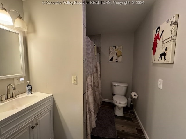 bathroom with vanity, toilet, wood-type flooring, and walk in shower